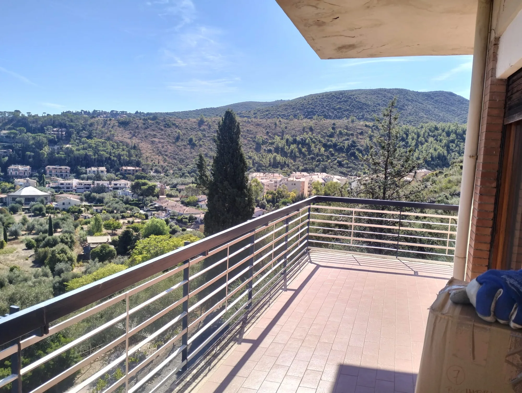 Uno scatolone e i guanti da lavoro sul terrazzo, durante un trasloco